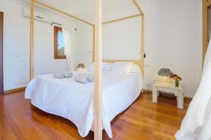 a bedroom with a large white bed and a mirror at Luxury finca Ses Quaranta in Campos +41 photos