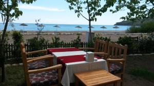 a table and chairs with a view of the beach at Hotel Yavuz Bungalow in Cıralı