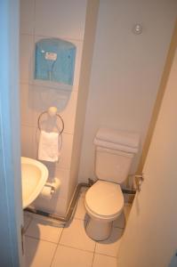 a small bathroom with a toilet and a sink at Parque Arauco Departamento Estudio Las Condes in Santiago