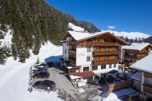 un lodge de esquí con coches aparcados en la nieve en Haus Markus, en Hintertux