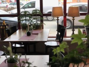 a table and chairs in front of a window with plants at Jennys Hotell och Restaurang in Arvika