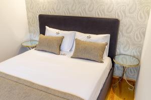 uma cama branca com duas almofadas e duas mesas em InSitu Formosa 178 by Guestify em Porto