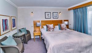 um quarto de hotel com uma cama, uma secretária e uma cadeira em Stradey Park Hotel em Llanelli