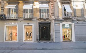 un edificio con ventanas de tiendas con maniquíes. en Chiaia 197 Deluxe Residence, en Nápoles