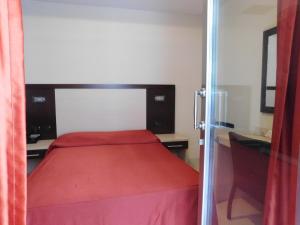 a bedroom with a red bed and a desk at Hotel Risberg in Gallipoli