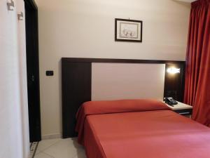 a bedroom with a bed with a red bedspread at Hotel Risberg in Gallipoli
