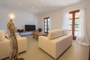 a living room with two white couches and a television at Luxury finca Ses Quaranta in Campos