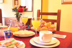 una mesa con dos vasos de zumo de naranja y pan en Posada Fernanda, en Pomar