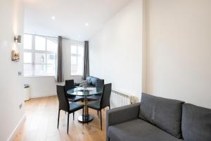 a living room with a couch and a table and chairs at StayInn Old Street in London
