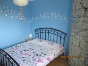 a blue bedroom with a bed with flowers on it at Maisonette Endless Blue in Sinemorets