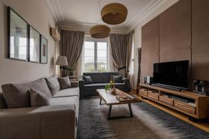 un soggiorno con divano e TV di Acropolis Exclusive Residences ad Atene
