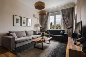 アテネにあるAcropolis Exclusive Residencesのソファとテーブルのあるリビングルーム