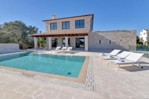 une villa avec piscine devant une maison dans l'établissement Villa Corso, à Portocolom