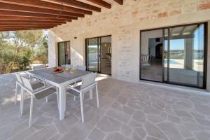 une salle à manger avec une table et des chaises sur un patio dans l'établissement Villa Corso, à Portocolom