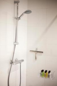 a shower with a shower head in a bathroom at Kuwadro Guesthouse Centrum in Amsterdam +23 photos