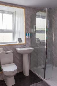 a bathroom with a toilet and a sink and a shower at Bannockburn Inn in Helmsdale
