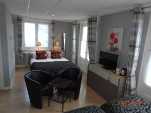 um quarto de hotel com uma cama, um sofá e uma televisão em Logis L'Ayguelade em Bielle