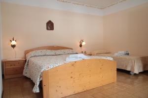 a bedroom with two beds and two lights on the wall at Albergo diffuso Valcellina e Val Vajont in Claut in Claut