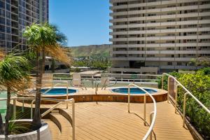 una terraza con 2 piscinas en un edificio en Hawaiian Sun Holidays en Honolulu