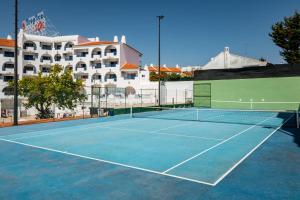 una pista de tenis frente a un edificio en Tropical Sol, en Albufeira