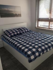 a bed with a blue and white checkered mattress in a bedroom at Apartament Aquarius Sopot in Sopot