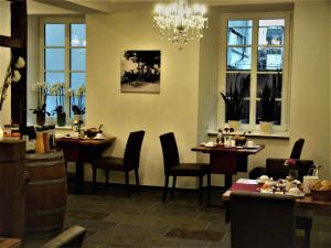 a restaurant with tables and chairs and a chandelier at Ferienweingut Rudorfer in Valwig