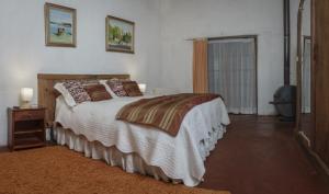 Un dormitorio con una cama grande y una ventana en La Casa de Adobe Natural y Más, en Bulnes