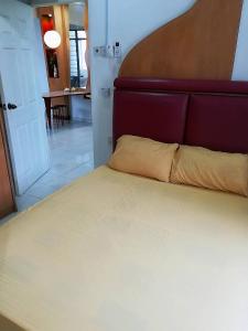 a bed with a large headboard and a room at Max Budget Hideout in Bayan Lepas