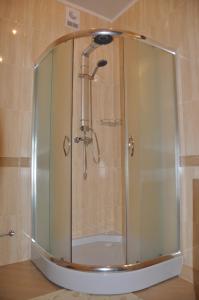 y baño con ducha y puerta de cristal. en Oazis-M, en Babin