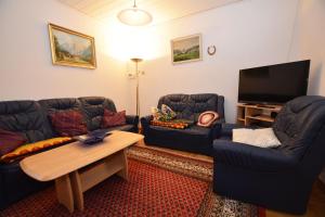 een woonkamer met twee banken en een flatscreen-tv bij Haus Emilie in Büsum