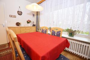 een eetkamer met een rode tafel en stoelen bij Haus Emilie in Büsum +10 foto's