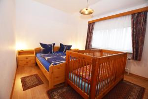 een slaapkamer met een wieg en een groot raam bij Haus Emilie in Büsum