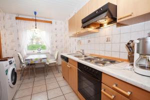 een keuken met een spoelbak en een fornuis bovenste oven bij Haus Emilie in Büsum