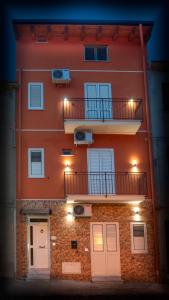 Asaro Camere في Campobello di Licata: مبنى برتقالي مع شرفة وباب