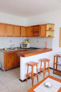 アリエタにあるSEA & RELAX - Apartament 2 Izqのキッチン(木製キャビネット、シンク、スツール2つ付)