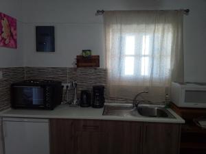 a kitchen with a sink and a microwave at Amazing View Dream House in Chora Folegandros +13 photos