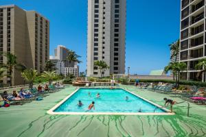 una piscina en un complejo con gente dentro en Sweetwater at Waikiki, VRI Americas en Honolulu