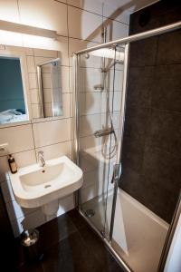 een badkamer met een wastafel en een douche bij B&B De Meren in Aarschot