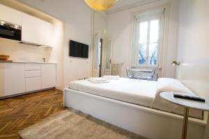 a white bedroom with a large white bed and a window at Brera Design and Bright Flat in Milan