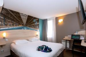 a hotel room with a bed with a laptop on it at Brit Hotel La Rochelle Périgny in Périgny