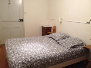 a bedroom with a bed with a black and white comforter at Auberge du prieure in Saint-André-de-Rosans