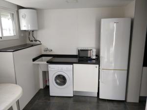 a kitchen with a refrigerator and a washing machine at Hello Oliva Beach BB in Oliva