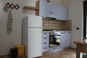 a kitchen with white cabinets and a white refrigerator at Villa delle Sirene in Ascea