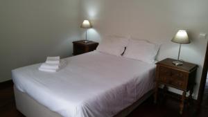 een slaapkamer met een wit bed en 2 nachtkastjes bij Barra's Beach Apartment in Praia da Barra
