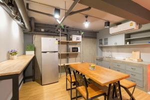 a kitchen with a wooden table and a refrigerator at Red Pin Inn 好运旅馆 in Bangkok