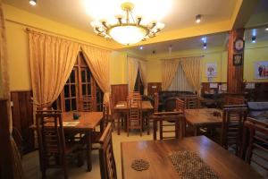 a restaurant with wooden tables and chairs and a chandelier at ABC Guest Inn & Restaurant in Haputale +43 photos