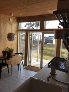 a kitchen with a table and a large window at Båstad Ateljehus in Båstad