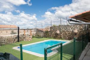 una piscina en un patio con una pared de piedra en Casa Rural El Portalino, en Ruanes