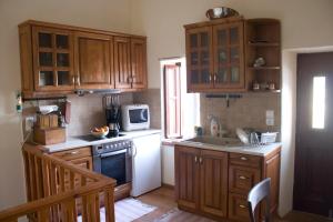 a kitchen with wooden cabinets and a white microwave at Irene's House in Olympos