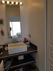 a bathroom with a sink and a mirror at Vue mer.Tranquilité.Cap d'Ail à 10 mn de MONACO in Cap d'Ail
